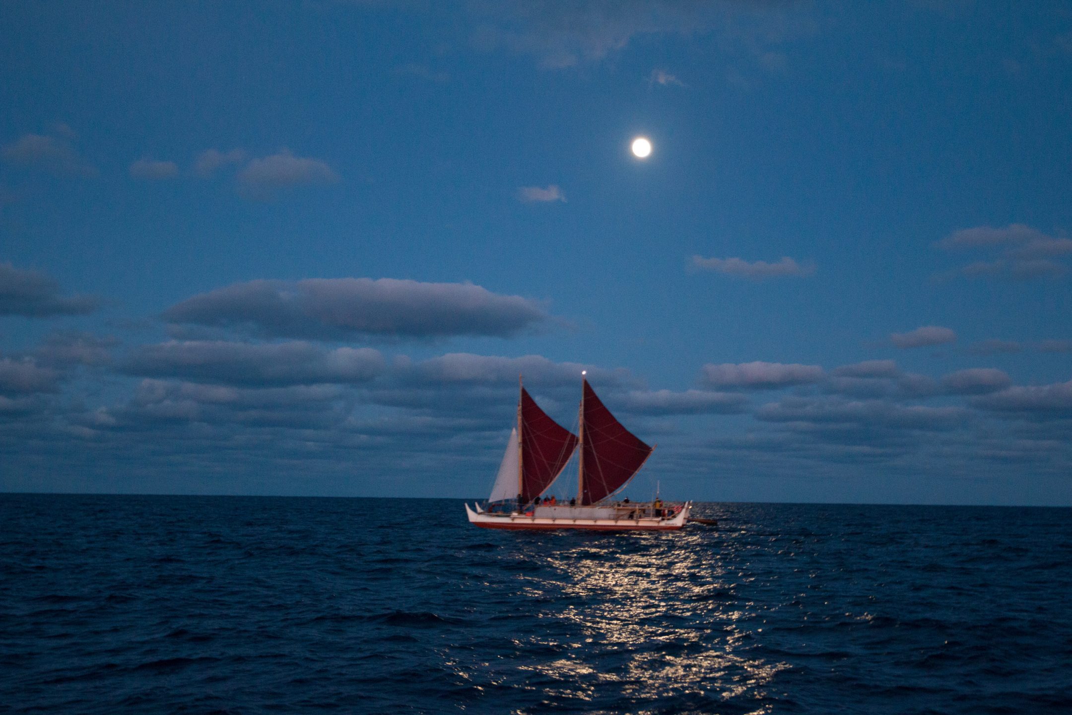 Hokulea sailing under a full moon